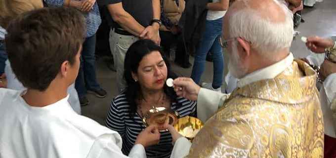 Mons. Celestino As accede a dar la comunin a los fieles que se arrodillan al comulgar