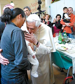 Benedicto XVI come con un grupo de pobres en un comedor social de Roma