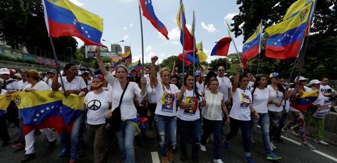 Decenas de miles de opositoras de blanco y con rosas marchan en Venezuela contra Maduro