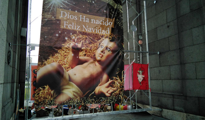 «Jóvenes por España» coloca un cartel navideño en la Puerta de Alcalá de Madrid